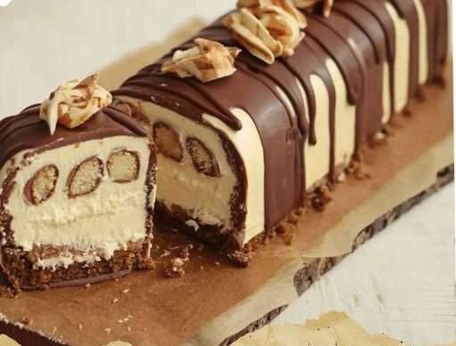 Une Bûche au Kinder Bueno garnie de crème onctueuse et décorée de morceaux de Kinder Bueno.