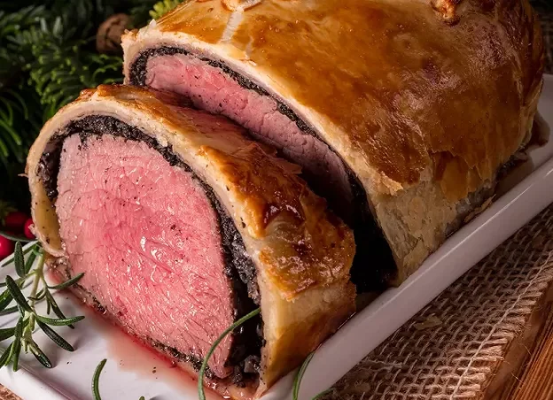 Filet de bœuf en croûte avec foie gras, doré et tranché, accompagné d'une sauce madère