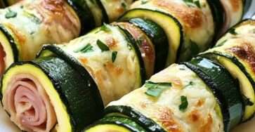 Roulés de courgettes au jambon et fromage ail et fines herbes, joliment disposés sur un plat de service, prêts à être dégustés.