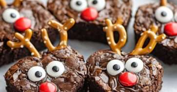 Brownies festifs en forme de rennes avec bois en bretzels, yeux en bonbons et nez rouges en Smarties, présentés sur une assiette de Noël.