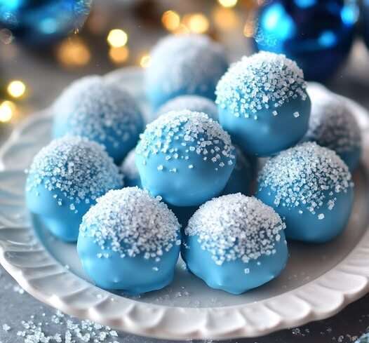 Des truffes bleues scintillantes, roulées dans du sucre cristallisé, placées sur un plateau élégant pour une présentation festive.