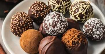 Un plateau élégant de truffes au chocolat, roulées dans différents enrobages comme le cacao, la noix de coco et les éclats de noisette.