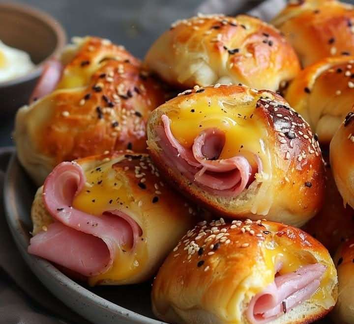 Rouleaux dorés de pain de mie farcis au jambon et fromage fondant, servis chauds