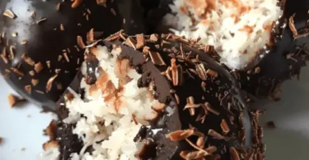 Boules de noix de coco enrobées de chocolat fondu disposées sur un plateau