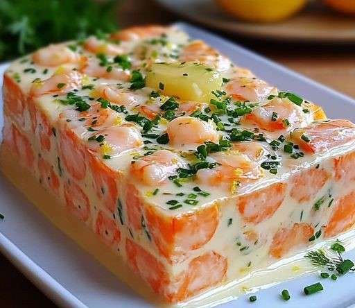 Terrine de Saint Jacques, saumon et crevettes, servie avec une salade verte et un filet de citron