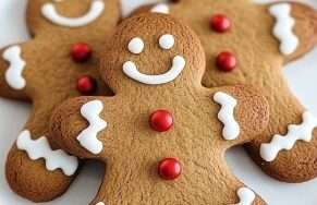 Biscuits bonshommes de Noël en pain d’épices décorés avec du glaçage blanc et des perles de sucre.