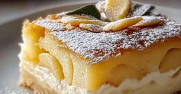 Un gâteau doré au yaourt, garni de poires juteuses et parsemé d’amandes, idéal pour une pause gourmande.