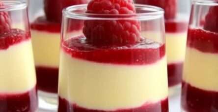 Verrine de mousse au chocolat blanc et à la framboise avec décoration de framboises fraîches et menthe