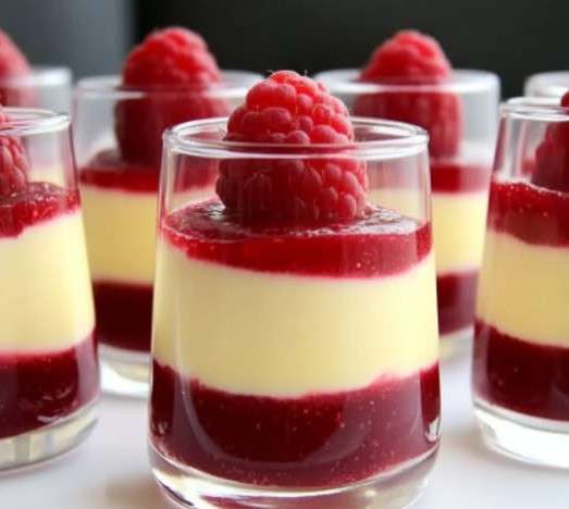 Verrine de mousse au chocolat blanc et à la framboise avec décoration de framboises fraîches et menthe