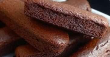 Financiers au chocolat dorés et moelleux, servis sur une assiette avec des copeaux de chocolat et une tasse de café.