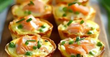 Mini quiches dorées aux poireaux et saumon fumé, décorées de ciboulette sur une assiette élégante