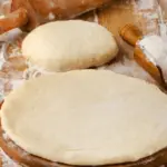 Une pâte à pizza maison étalée, prête à être garnie avec des ingrédients frais