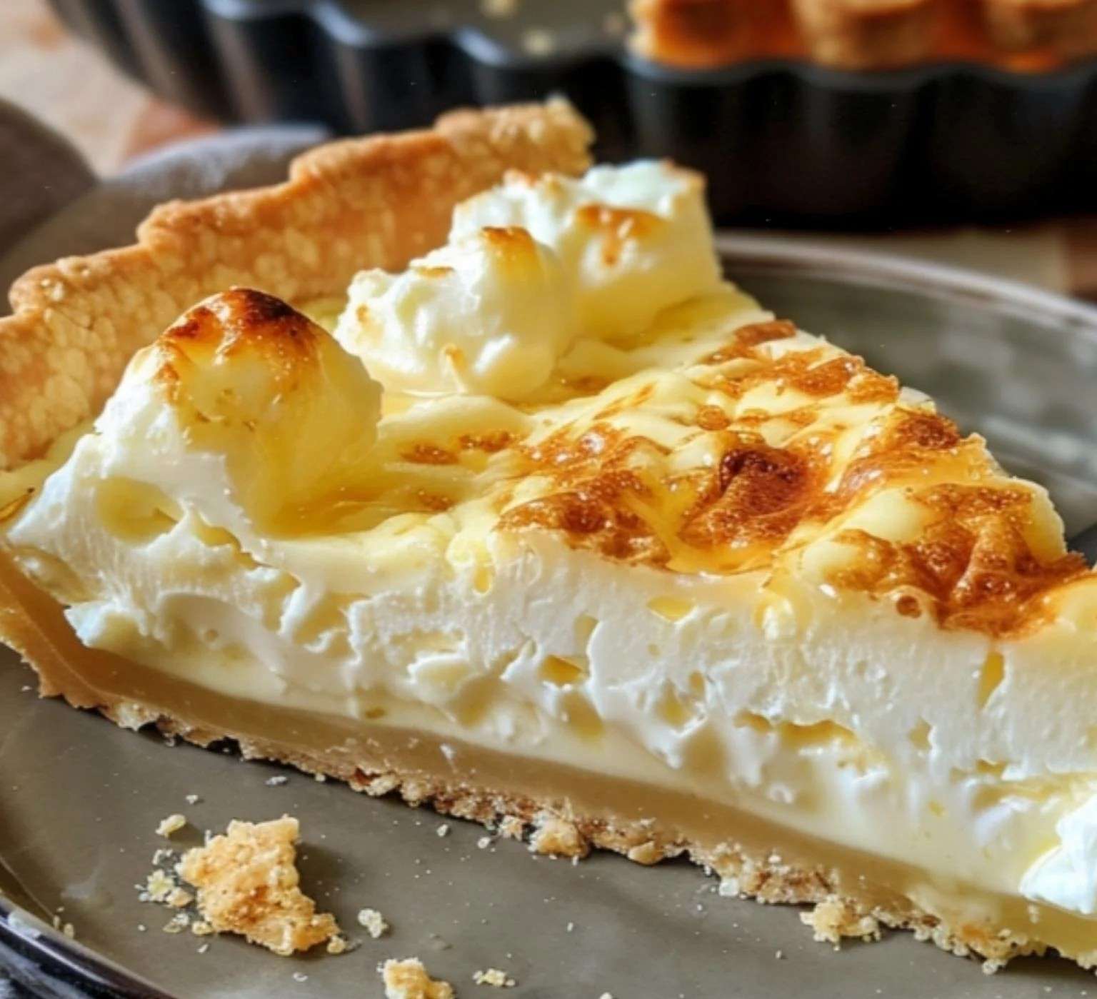 Une tarte alsacienne au fromage blanc dorée et moelleuse, légèrement soufflée, servie avec une touche de sucre glace et des zestes de citron.