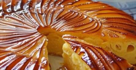 Un gâteau breton doré et sablé, avec de belles incisions en croisillons, servi en parts épaisses sur une planche en bois.