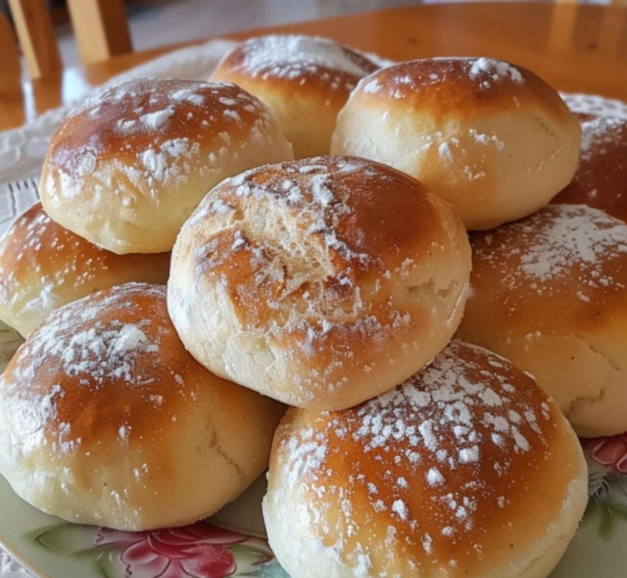 Petites brioches au yaourt dorées et moelleuses, servies sur une assiette avec un fond rustique en bois et un bol de confiture.