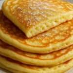 Panqueques de requesón esponjosos servidos con frutas frescas y miel