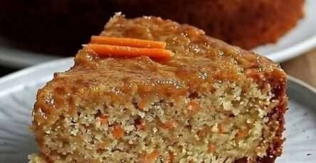 Rebanadas de torta de avena y zanahoria servidas en un plato blanco con nueces y plátano de fondo sobre una mesa rústica.