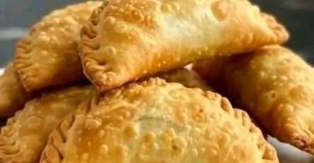 Empanadas fritas doradas rellenas de carne servidas con salsa picante