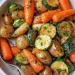 Plateau de légumes rôtis au four avec pommes de terre, carottes, courgettes, ail et herbes provençales