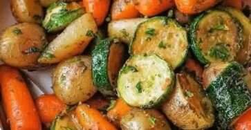 Plateau de légumes rôtis au four avec pommes de terre, carottes, courgettes, ail et herbes provençales