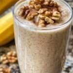 Batido cremoso para aumentar masa muscular servido en vaso con avena y nueces