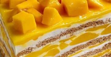Carlota de mango casera decorada con trozos frescos de mango