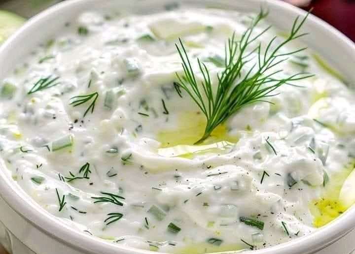 Tazón de tzatziki cremoso con pepino rallado y ramitas de eneldo