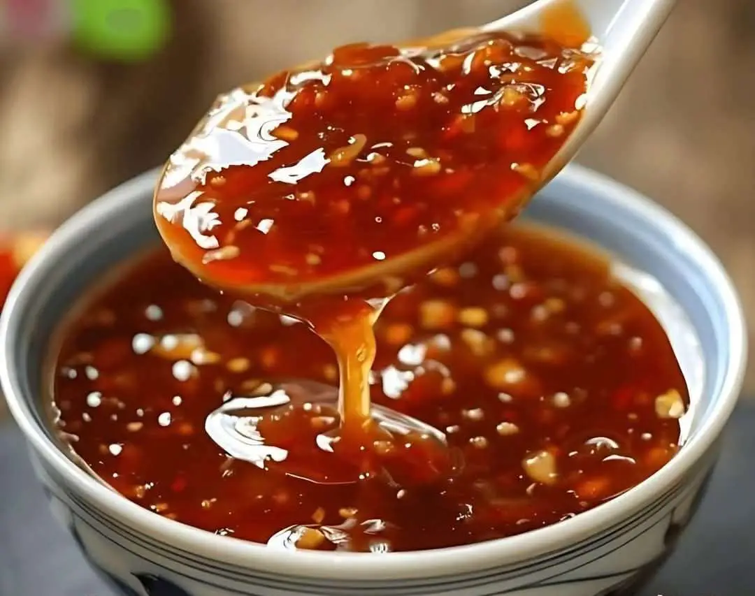 Salsa agridulce china casera servida en tazón blanco con cuchara