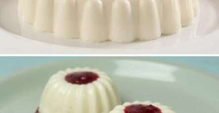 Gelatina de yogurt blanca servida en vasitos transparentes, decorada con fruta fresca y hojas de menta sobre una mesa de madera clara.