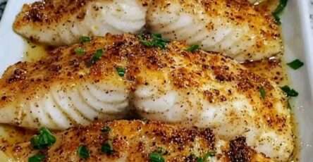 filete de pescado con mantequilla de limón y ajo servido con rodajas de limón