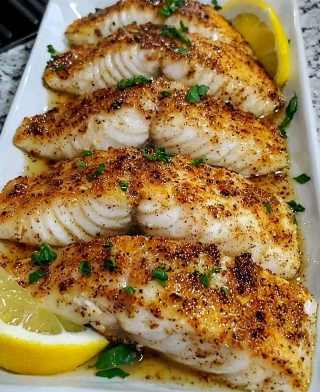 filete de pescado con mantequilla de limón y ajo servido con rodajas de limón