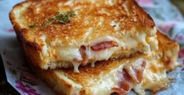 croque-monsieur croustillant au bacon & cheddar doré et fondant servi chaud avec une touche de thym frais