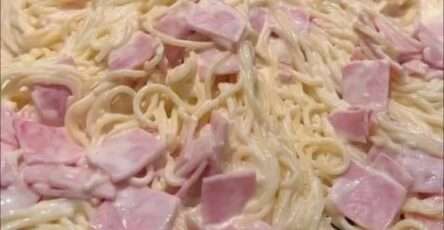 Plato de espagueti blanco cremoso con jamón y queso manchego fundido