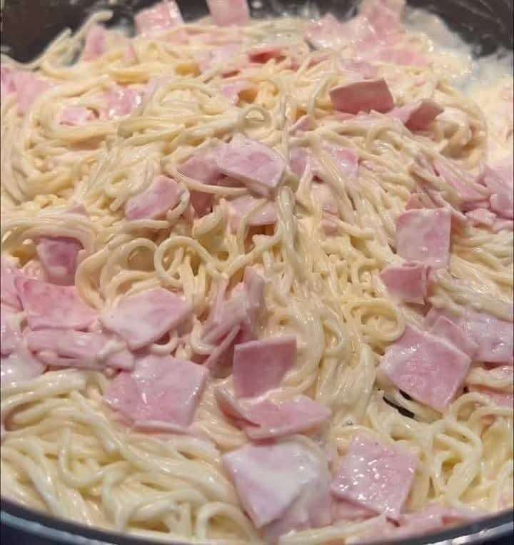Plato de espagueti blanco cremoso con jamón y queso manchego fundido
