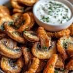 Champignons frits dorés et croustillants accompagnés d'une sauce ranch crémeuse, servis dans un bol rustique pour un apéritif gourmand fait maison.