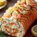 Roulé de saumon fumé au fromage frais, crevettes et aneth sur assiette décorée