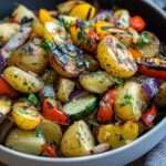 Salade colorée de pommes de terre rôties et légumes grillés aux herbes dans un grand bol noir