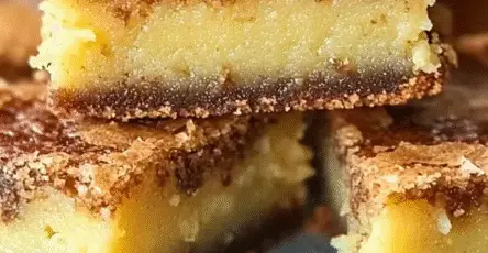 Carrés de moelleux frangipane au rhum, texture fondante et croûte dorée, présentés en pile gourmande, dessert maison raffiné.