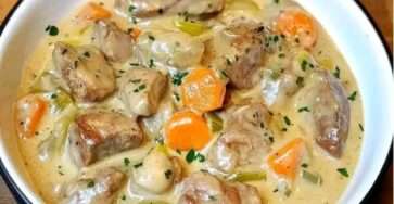 Blanquette de veau à l’ancienne servie dans une cocotte, viande fondante, légumes colorés et sauce blanche onctueuse, parsemée de persil frais.