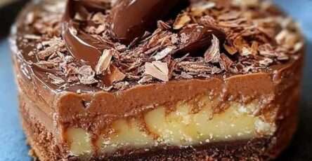 Part de gâteau crousti-fondant chocolat-poire sur une assiette, décorée de lamelles de poire et copeaux de chocolat.