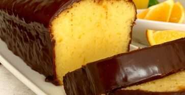 Gâteau à l’orange moelleux décoré de zestes et de rondelles d’orange.
