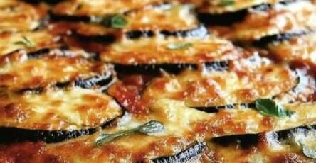 Délicieux gratin d’aubergines à l’italienne, fondant, doré, recouvert de fromage et de basilic frais.