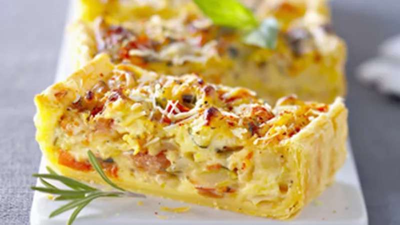 Flan provençal – Tarte salée dorée, légumes méditerranéens, courgettes, tomates cerises, crème, gruyère, part gourmande sur fond rustique.