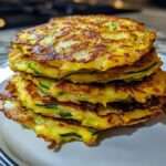 Assiette de röstis de courgettes croustillants servis chauds avec une sauce au yaourt et persil frais