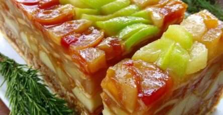 Tranches de terrine brillante aux pommes et poires caramélisées, décorées de lamelles de pomme verte, servies sur une assiette raffinée.