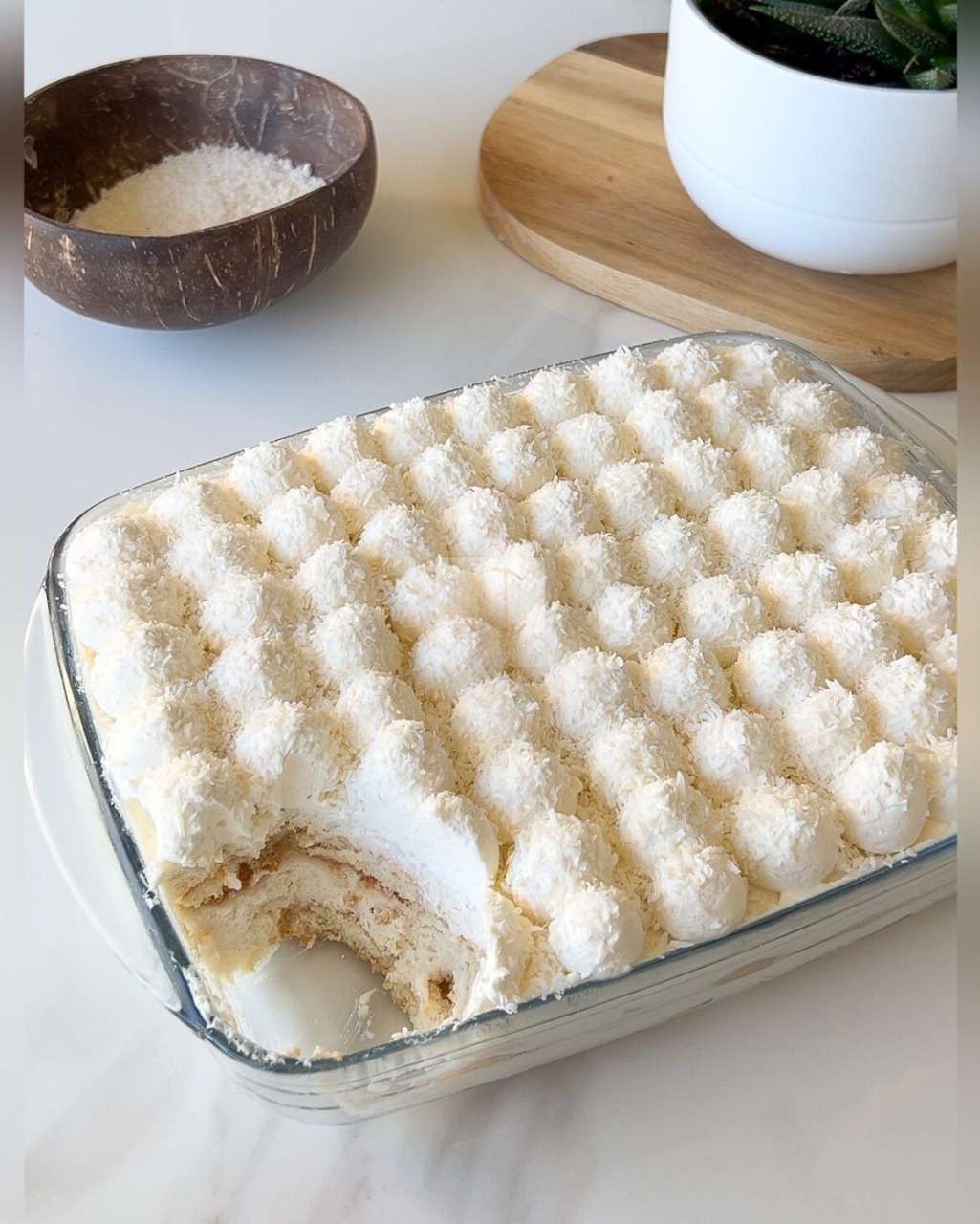 Tiramisu Raffaello maison, crémeux, décoré de crème montée et de noix de coco.