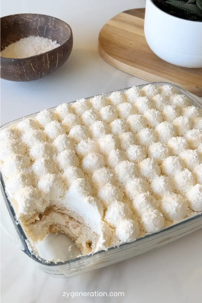 Tiramisu Raffaello maison, crémeux, décoré de crème montée et de noix de coco.