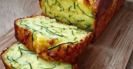 Pain de courgette et fromage moelleux, tranché, servi sur planche en bois avec salade