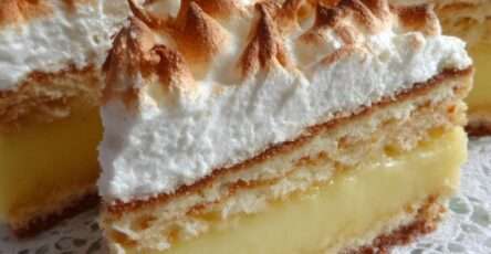 Gâteau citron-meringue en couches avec génoise moelleuse, crème au citron et meringue dorée au chalumeau.