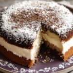 Gâteau moelleux à la noix de coco et crème décoré de chocolat râpé et de coco